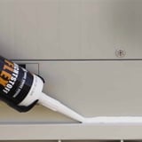 Afdichtingskit FLEX in witte kleur wordt met kitpistool op metalen voeg aangebracht