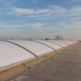 Rij Alumon lichtkoepels op een plat dak onder een blauwe lucht