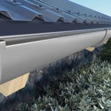Grijze PVC dakgoot van Plastmo aan een dak met damwandplaat en houten spanten