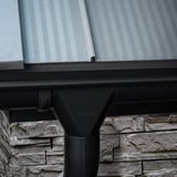 Niagara gitzwarte stalen dakgoot met afvoerbuis en Niagara logo onder een dak met lichtplaten