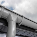Niagara dakgoot in grijs aluminiumkleurig (RAL9007) met waterdruppels na regen