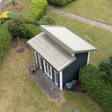 Dakpanplaat Grijswit RAL 9002 op het lessenaarsdak van een tuinhuis, bovenaanzicht