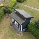 Dakpanplaat 2/1060 aluminium RAL9007 op een modern tuinhuis met lessenaarsdak, van bovenaf gezien
