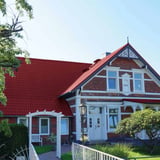Dakpanplaat 2/1060 Wijnrood op een woonhuis met dakkapellen, gemonteerd