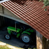 Dakpanplaat EUROPA Roodbruin (RAL 8012) op een schuurdak, daaronder een groene tractor