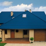Huis met dak van blauwe dakpanplaat Szafir 350/15 in Gentiaanblauw, 0,50 mm staal