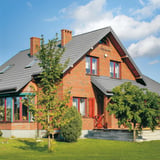 Bakstenen huis met dak van dakpanplaat Szafir 350/15 Zilver-Metallic