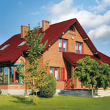 Bakstenen huis met dak van kersrode dakpanplaat Szafir 350/15, 0,40 mm