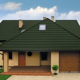 Huis met dak van dakpanplaat Szafir 350/15 Chroomoxydegroen, vooraanzicht met garage