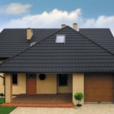 Dak met dakpanplaat Szafir 350/15 Grafietgrijs op een beige woonhuis met dakkapellen