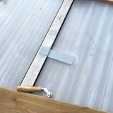Dak reparatieband EPDM grijs, klein stukje op een lichtplaat met aandrukrol