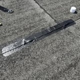 Dak reparatieband, zwarte EPDM-band op dakoppervlak gelegd, schaar en rol op de achtergrond