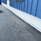 Geïnstalleerde witte dak reparatieband aan een muur op een plat dak