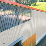 Industriegebouw met wandbekleding van damwandplaat 20/1100 in Zuiverwit (RAL 9010) en lichtplaten