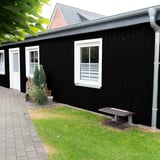 Damwandplaat 20/1100 Gitzwart als gevelbekleding van een aanbouw met ramen en deur