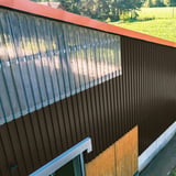 Gebouwwand met Chocoladebruin damwandplaat 20/1100 Wand en transparante lichtplaten bovenaan
