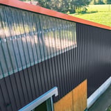 Gebouwwand met antracietgrijze damwandplaat 20/1100 en transparante lichtplaten