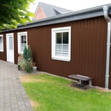 Gebouwwand met damwandplaat 20/1100 Notenbruin (RAL 8011) en witte ramen