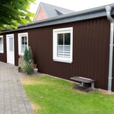 Damwandplaat 20/1100 wand, Chocoladebruin RAL 8017, aan een aanbouw met witte ramen