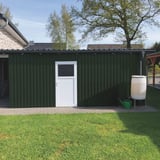 Damwandplaat 20/1100 wand mosgroen als bekleding van een tuinhuis met witte deur en regenton