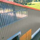 Damwandplaat 20/1100 aluminium 0,70 mm, RAL9007, als gevelbekleding van een hal met lichtplaten