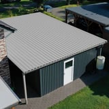 Damwandplaat 35/207 lichtgrijs RAL 7035 op een garagedak met dakgoot