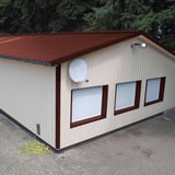 Damwandplaat 35/207, Roodbruin (RAL 8012) op een opslaggebouw met lichte wanden