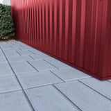 Detailaanzicht van de onderrand van damwandplaat 35/207 wand Wijnrood (RAL 3005) op een muur