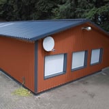 Damwandplaat 35/207 wand koperbruin op een gebouw met dak en ramen