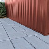 Detailaanzicht van de onderrand van damwandplaat 35/207 aluminium 0,70 mm roodbruin aan een muur
