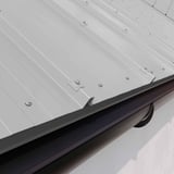 Dakgootprofiel Zilver-Metallic op dak met donkere dakgoot en damwandplaat gemonteerd