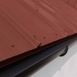 Plaatsing: dakgootprofiel aluminium Roodbruin (RAL 8012) op dak met zwarte dakgoot