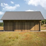 Felsplaat 33/500-LE, grijs aluminium, als dakbedekking op een houten gebouw