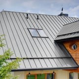 Dakoverzicht van een huis met lichtgrijze felsplaat PD-510-S trapezium en dakramen