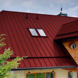 Staande felsplaat PD-510-S trapezium kersrood op een woonhuis, detailweergave van het dak met twee dakramen