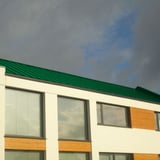 Modern gebouw met mintgroen staande felsplaat PD-510-S dak en grote ramen
