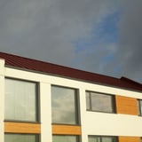 Felsplaat PD-510-S damwandplaat Roodbruin (RAL 8012) op een modern gebouw