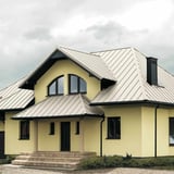 Staande felsplaat PD-510-S trapezium, zuiverwit, op een woonhuis met meerdere dakvlakken