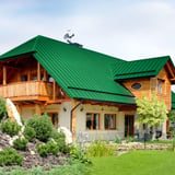 Groot huis met dak van mintgroene felsdakpan PD-510-S Micro, houten gevel