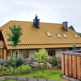 Groot huis met dak van felsplaat PD-510-S Micro Zandgeel (RAL 1002)