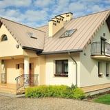 Felsplaat PD-510-S Micro, licht ivoorkleurig, gemonteerd op een woonhuis met dakkapellen en dakramen