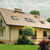 Felsplaat PD-510-S Micro, licht ivoorkleurig, gemonteerd op een woonhuis met dakramen en schoorstenen
