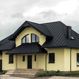 Huis met felsplaat PD-510-S Micro Grafietgrijs dak en gele gevel