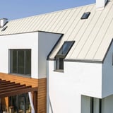 Felsplaat PD-510-S Micro Zuiverwit op een wit huis met dakramen en houten bekleding