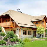 Huis met dak van felsdakpan PD-510-S in Licht ivoorkleurig (RAL 1015) en windwijzer