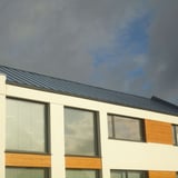 Felsplaat PD-510-S Pelsgrijs op een modern gebouw met grote ramen