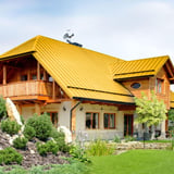 Huis met dak van felsplaat PD-510-S in Koolzaadgeel, met dakkapel en balkon