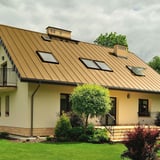 Huis met dak van felsplaat PD-510-S in Zandgeel (RAL 1002) met dakramen