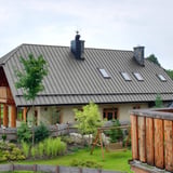 Felsplaat PD-510-S Zilver-Metallic op een groot woonhuis met dakkapellen en dakramen
