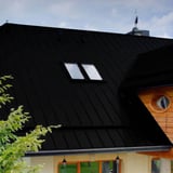 Staande felsplaat PD-510-S Vlak Gitzwart op een woonhuis, close-up van het dak met dakramen